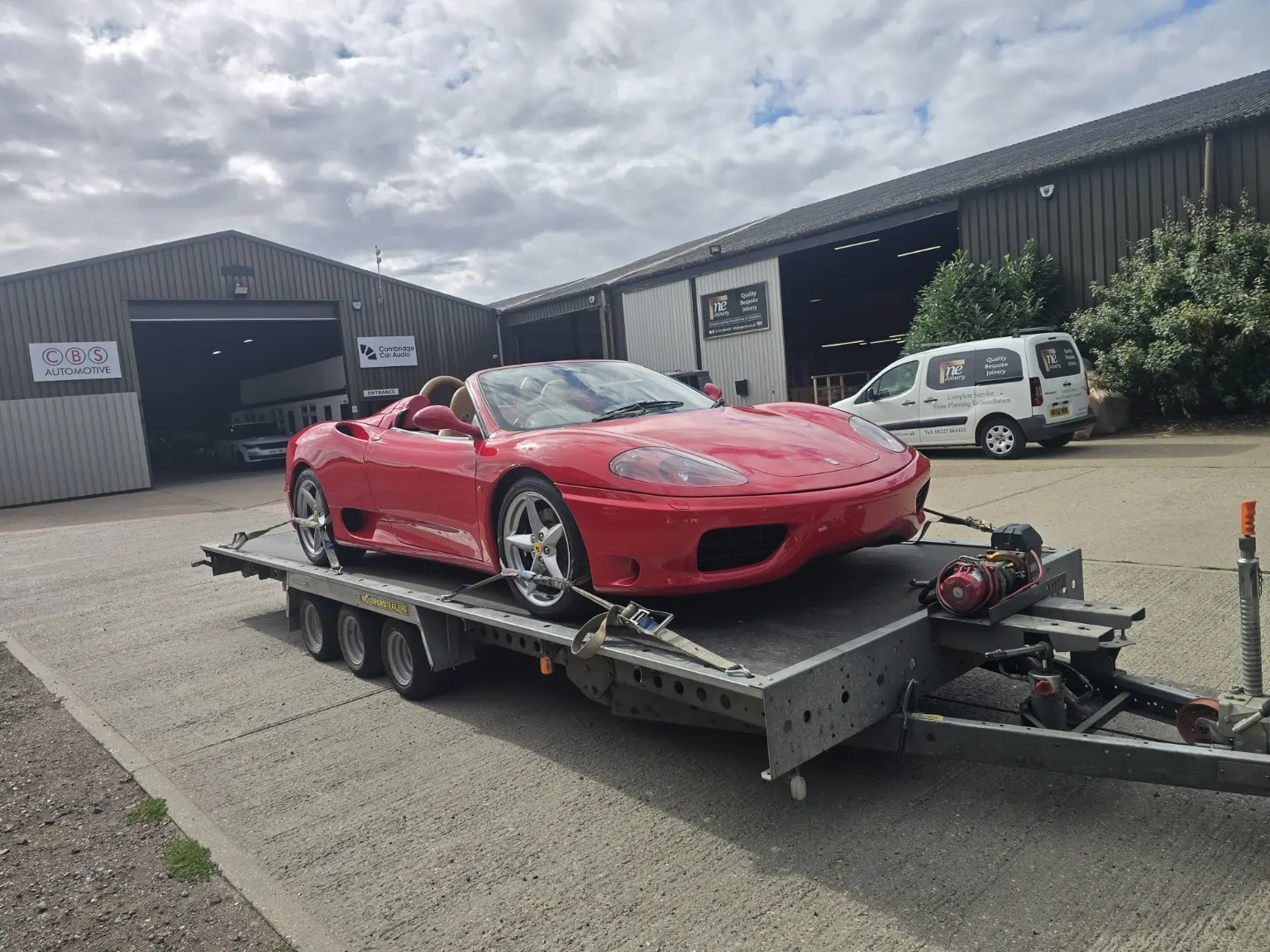 Red prestige sports car secured on an Alexander Recovery trailer